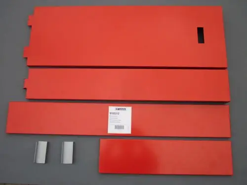 Rote, flache Metallteile von Remeha, inklusive ein Stück mit einer Aussparung und zwei metallischen Halterungen. Anordnung der Teile auf grauem Hintergrund.
